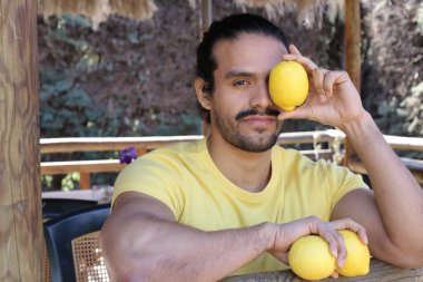 Açık havada limonlu sarı tişörtlü yakışıklı genç adamın portresi.