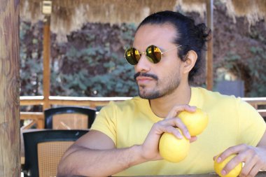 Açık havada limonlu sarı tişörtlü yakışıklı genç adamın portresi.