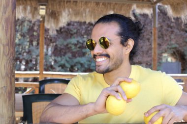 Açık havada limonlu sarı tişörtlü yakışıklı genç adamın portresi.