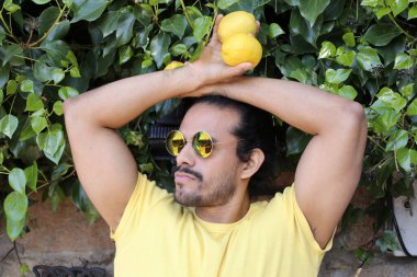 Açık havada limonlu sarı tişörtlü yakışıklı genç adamın portresi.