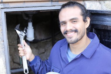 İngiliz anahtarı olan yakışıklı bir tesisatçının portresi.