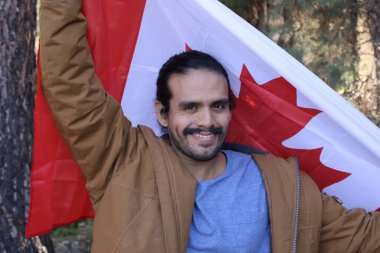 Sokakta Kanada bayrağı taşıyan yakışıklı genç adamın portresi.