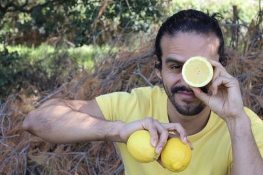 Açık havada limonlu sarı tişörtlü yakışıklı genç adamın portresi.
