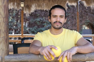 Açık havada limonlu sarı tişörtlü yakışıklı genç adamın portresi.