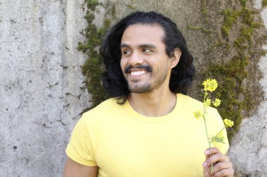 Dışarıdaki sarı tişörtlü yakışıklı genç adamın portresi.