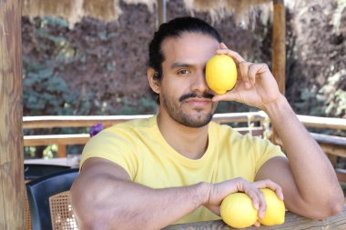 Açık havada limonlu sarı tişörtlü yakışıklı genç adamın portresi.