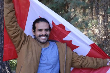 Sokakta Kanada bayrağı taşıyan yakışıklı genç adamın portresi.