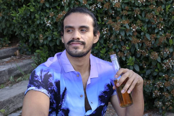 ビールのボトルを屋外でスタイリッシュな紫色のシャツでハンサムな若い男の肖像画 — ストック写真