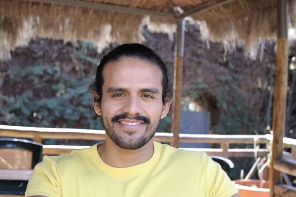 Dışarıdaki sarı tişörtlü yakışıklı genç adamın portresi.