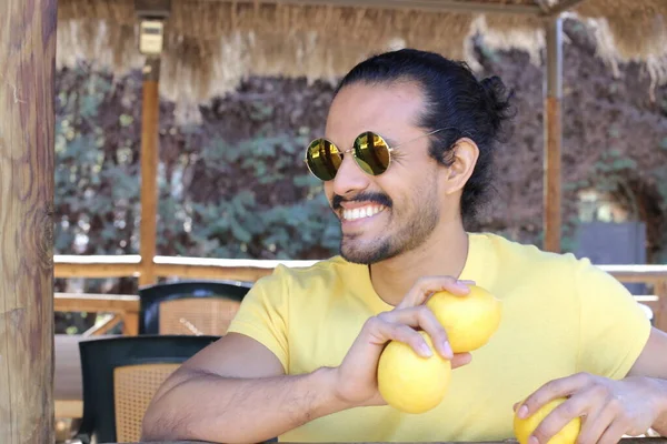 Açık havada limonlu sarı tişörtlü yakışıklı genç adamın portresi.