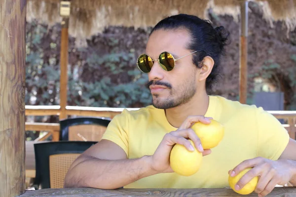 Açık havada limonlu sarı tişörtlü yakışıklı genç adamın portresi.