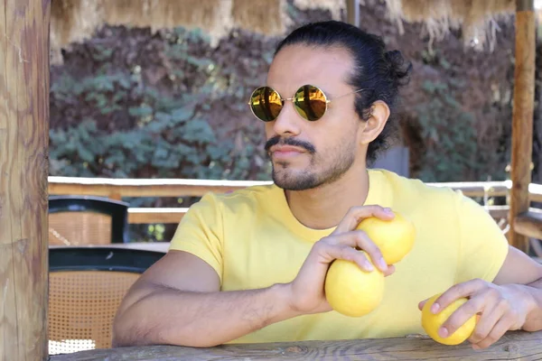 Açık havada limonlu sarı tişörtlü yakışıklı genç adamın portresi.