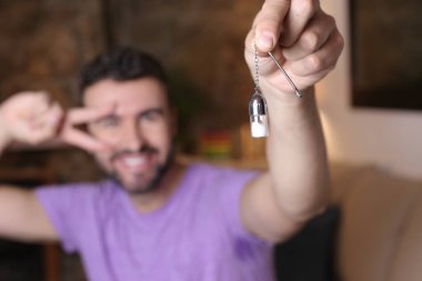 close-up portrait of handsome young man holding small glass pill case at home