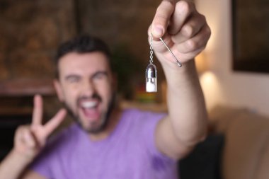 close-up portrait of handsome young man holding small glass pill case at home