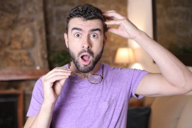 Evinde kırık gözlüklü yakışıklı bir gencin yakın plan portresi.