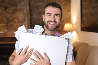 Evinde para dolu bir çanta taşıyan yakışıklı bir gencin yakın plan portresi.