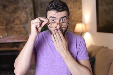 Evinde kırık gözlüklü yakışıklı bir gencin yakın plan portresi.