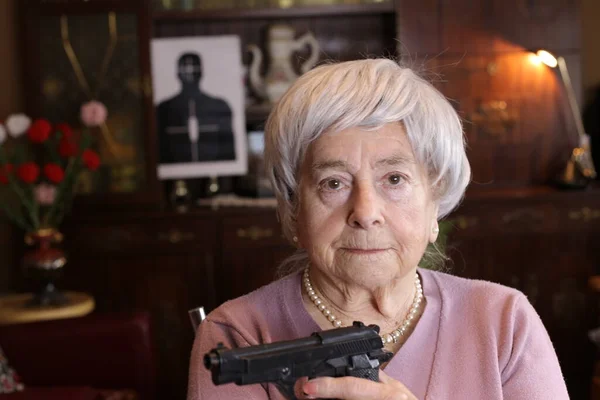 自宅に拳銃を持った熟女のクローズアップ肖像画 — ストック写真