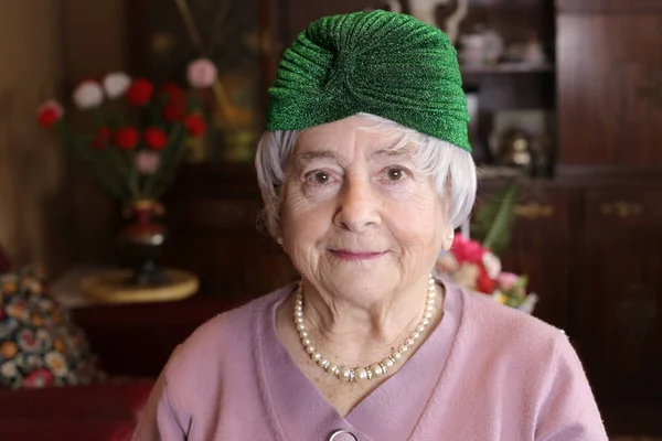自宅の緑の帽子を被った大人の女性の肖像画 — ストック写真
