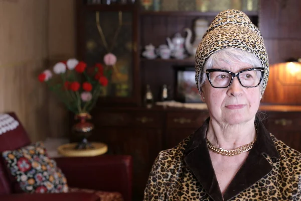 自宅で帽子をかぶったヒョウのジャケットの成熟した女性のクローズアップ肖像画 — ストック写真