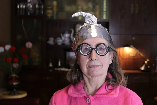 自宅のアルミホイルの帽子の成熟した女性のクローズアップ肖像画 — ストック写真