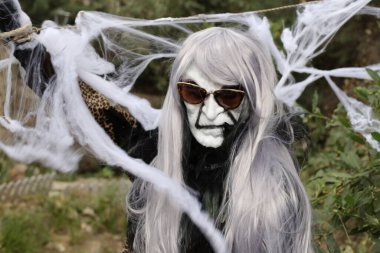 Örümcek ağıyla çevrili korkunç Cadılar Bayramı maskeli kişinin yakın plan portresi.