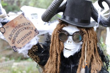 Korkunç Cadılar Bayramı maskeli, elinde ruh çağırma tahtası olan birinin yakın plan portresi.