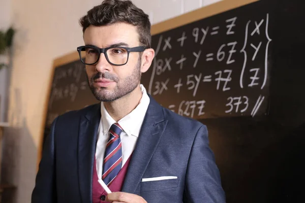 在教室里穿着西装 打着领带 站在黑板前的年轻英俊教师的特写 — 图库照片