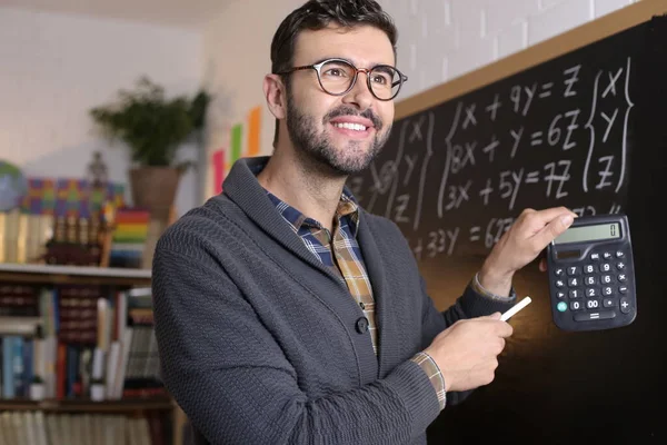 Close Portrait Handsome Young Teacher Holding Chalk Calculator Front Blackboard — Fotografia de Stock