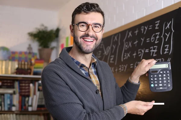 Close Portrait Handsome Young Teacher Holding Chalk Calculator Front Blackboard —  Fotos de Stock