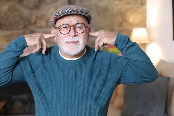 Evde Parmaklarıyla Kulaklarını Kapatan Yakışıklı Yaşlı Adamın Yakın Plan Portresi — Stok fotoğraf