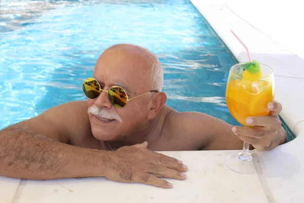 晴れた夏の日にプールでトロピカルカクテルを飲む大人の男性の肖像画 — ストック写真