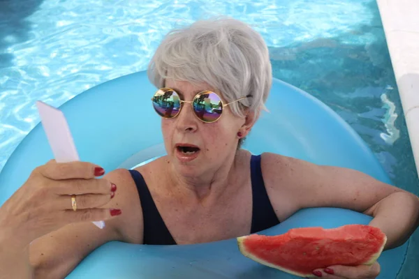 Portrait Mature Woman Swimsuit Slice Watermelon Using Smartphone Pool Sunny — Stock Photo, Image