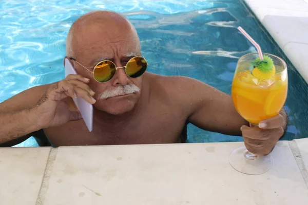 Portrait Mature Man Glass Tropical Cocktail Talking Phone Pool Sunny — Stock Photo, Image