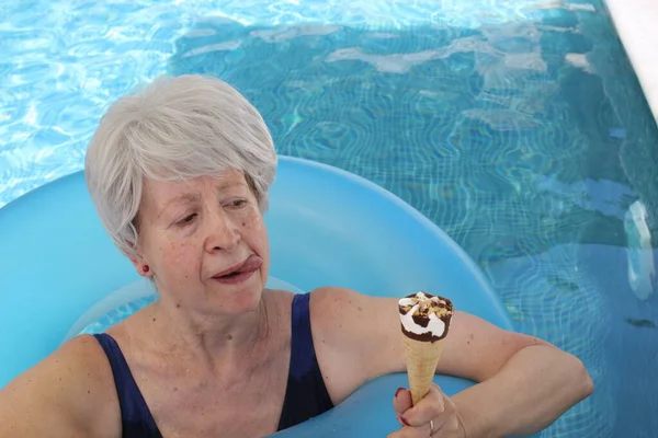 Portrait Mature Woman Swimsuit Inflatable Tube Eating Ice Cream Pool — Stock Photo, Image