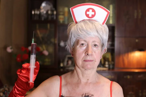 自宅で注射器で看護師のシルクの衣装で成熟した女性のクローズアップ肖像 ハロウィンお祝いのコンセプト — ストック写真