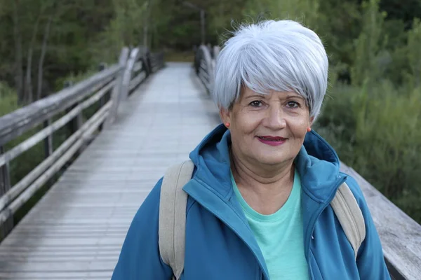 Parktaki Tahta Yaya Köprüsündeki Mutlu Yaşlı Kadının Yakın Plan Portresi — Stok fotoğraf