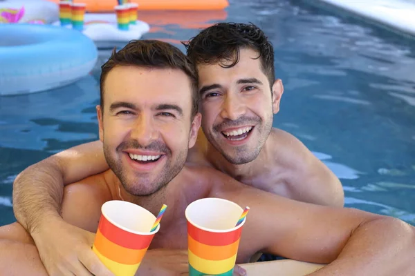 幸せな若いゲイのカップル楽しい時間を一緒にプールで紙コップを保持するLgbtフラグの色 — ストック写真