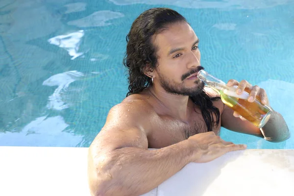 年轻英俊的男女混血男子与一瓶啤酒在游泳池里的特写 — 图库照片
