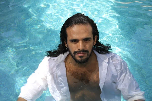 プールでの白いぬれたシャツのハンサムな若い混合人種の男のクローズアップポートレート — ストック写真