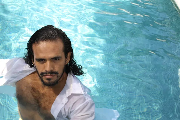 身穿湿白色衬衫的年轻混血男子在游泳池中的特写 — 图库照片