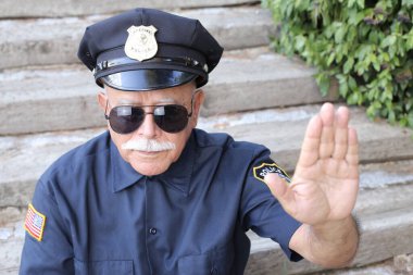 Polis kostümü giymiş yakışıklı son sınıf öğrencisinin açık hava hareketini gösteren yakın plan portresi.