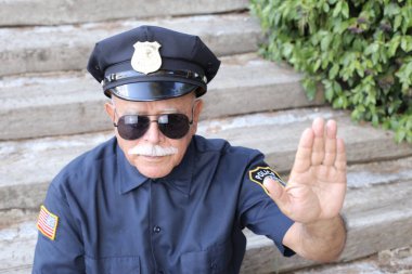 Polis kostümü giymiş yakışıklı son sınıf öğrencisinin açık hava hareketini gösteren yakın plan portresi.