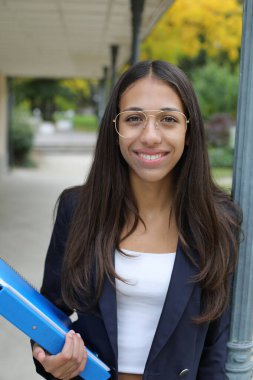 Dosyasıyla birlikte siyah ceketli mutlu genç kadın.