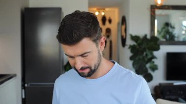 man in casual clothes making funny faces in home kitchen