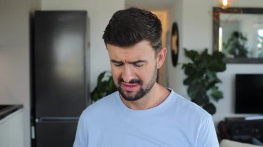 Genç yakışıklı adam evde şarkı söylüyor.