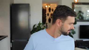 Mutfakta kameraya gülümseyen yakışıklı genç adam.