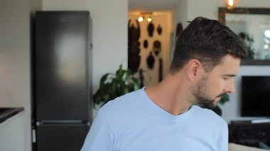 Mutfakta kameraya gülümseyen yakışıklı genç adam.