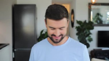 Mutfakta kameraya gülümseyen yakışıklı genç adam.