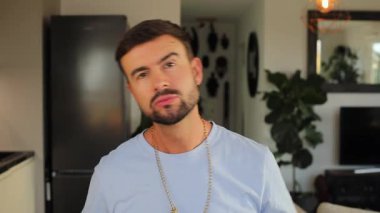 Kredi kartını tutan ve dolar işareti kolyesi takan bir adam.